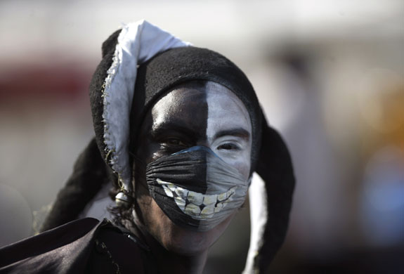 Swine flu face masks: A street performer wears a surgical mask painted with an image of teeth