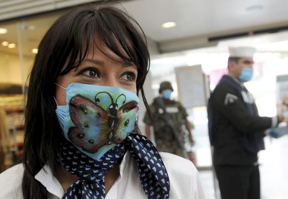 Swine flu face masks: A woman wears a surgical mask with a butterfly painted on it.
