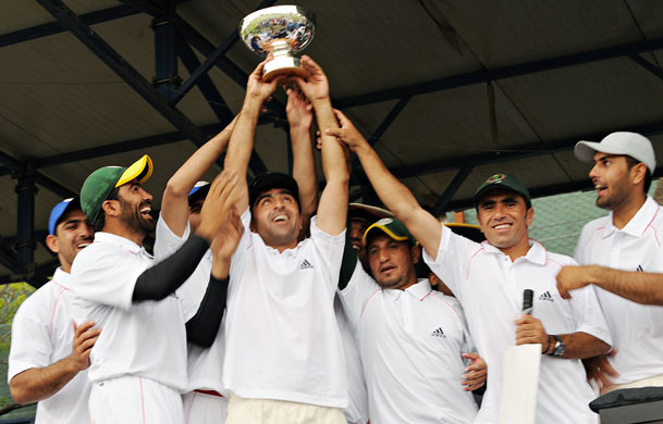 Afghanistan cricket: Cricketers from Afghanistan's national cricket team hold up a trophy.