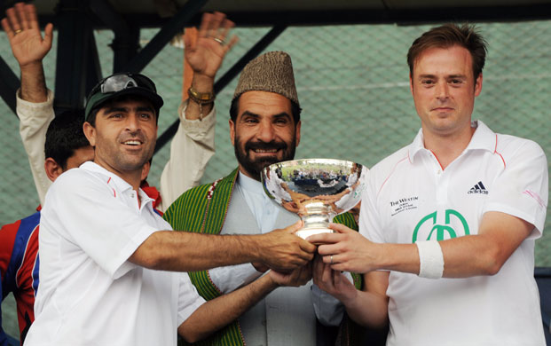 Afghanistan cricket: A member of Afghanistan's national cricket team holds a cup 