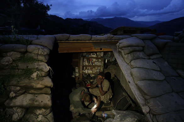24 hours in pictures: Korengal Valley, Afghanistan: A solider is treated in a medical bunker
