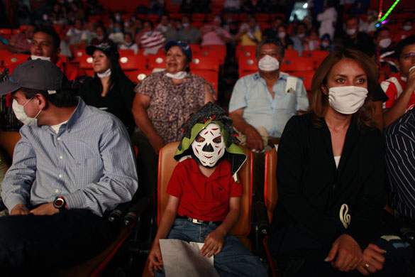 24 hours in pictures: Wrestling fans wearing face masks watch a match in Mexico City