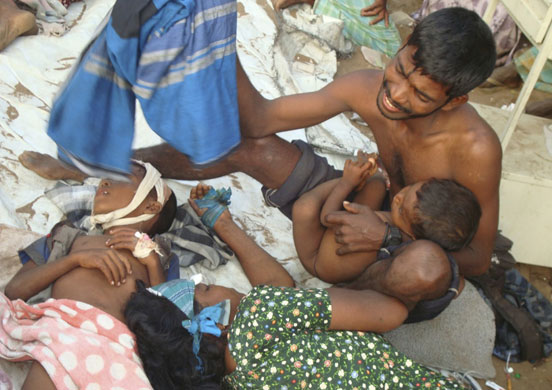 Sri Lanka : A Sri Lankan ethnic Tamil man weeps over the bodies of his family members 