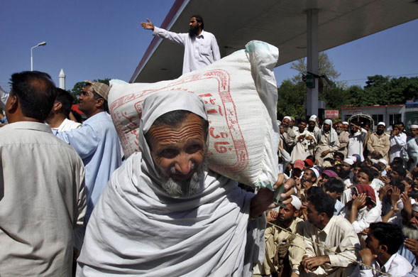 Pakistan Swat exodus: A man internally displaced from Swat Valley carries a sack at a relief camp