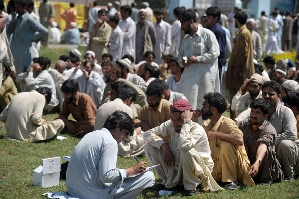 Pakistan Swat exodus: A Pakistani UNHCR official registers displaced men at a makeshift camp.
