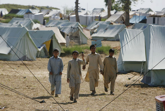 Pakistan Swat exodus: Pakistani boys walk through a refugee camp at Swabi, in northwest Pakistan