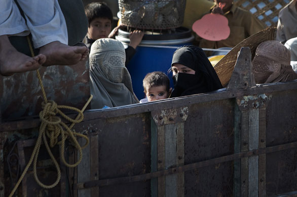 Pakistan Swat exodus: An internally displaced mother holds her baby as they travel by road