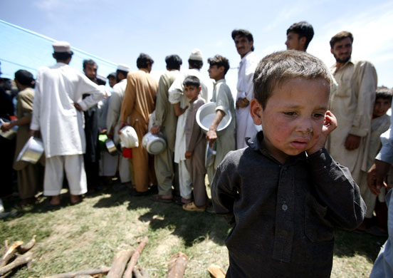 Pakistan Swat exodus: Children wait to get food at a refugee camp in Mardan