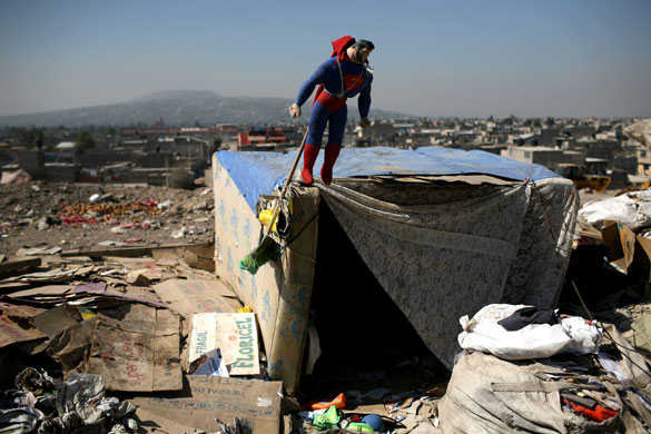 24 hours in pictures: Superman toy hangs from a hut made of mattresses in a trash dump, Mexico
