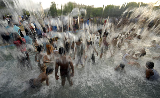 24 hours in pictures: Children play in a water fountain on a hot day in Hyderabad