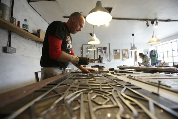 Holy Well Glass: Holy Well Glass. Greville Thorne works on the leading of a window