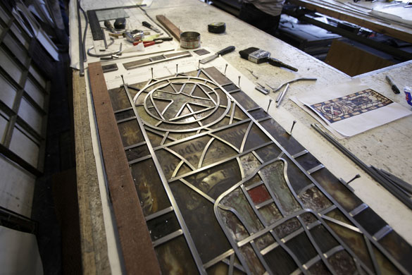 Holy Well Glass: Holy Well Glass  window is pinned in place while being reassembled
