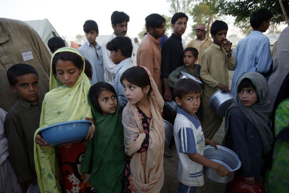 12 May 2009: Mardan, Pakistan: Children queue for food at a refugee camp