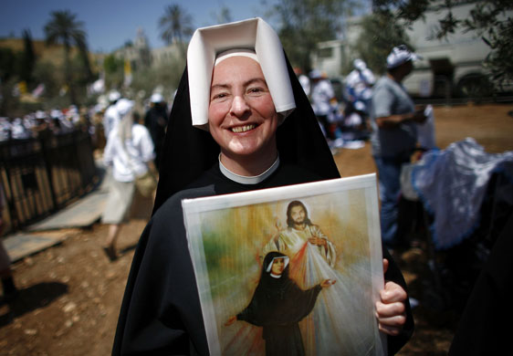 Pope Benedict XVI: A nun carries a picture of Jesus as she waits for Pope Benedict XVI