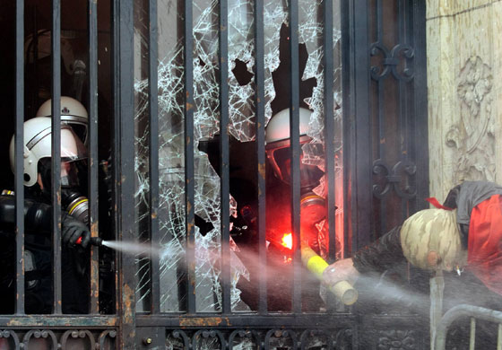 ArcelorMittal: A policeman sprays tear gas as a demonstrator tries to throw a firework