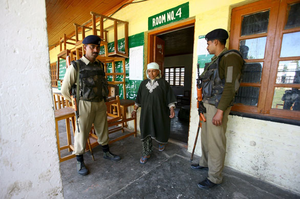 India Elections 5th Stage: Indian soldiers stand guard after a woman casts her vote in the elections