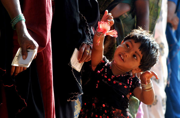 India Elections 5th Stage: An Indian girl waits with her parents who are voting in the Indian election
