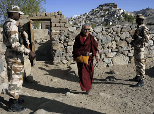 India Elections 5th Stage: Indian guards watch a Ladakhi monk arrive to vote in the Indian election