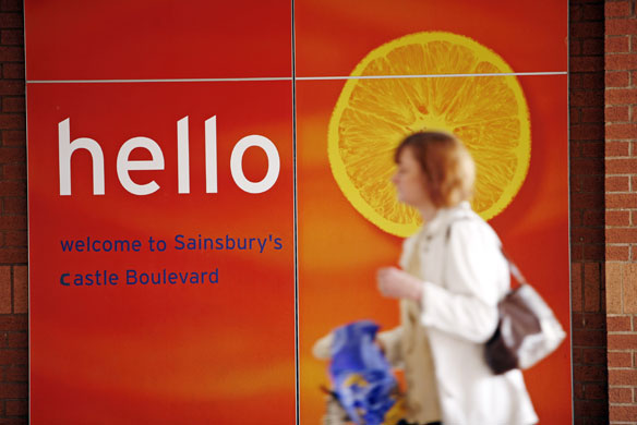 Week in business: A shopper passes the welcome sign at Sainsbury's supermarket in Nottingham.
