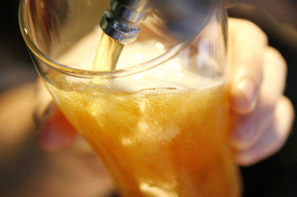 Week in business: A bartender prepares a beer in a bar in central Sydney