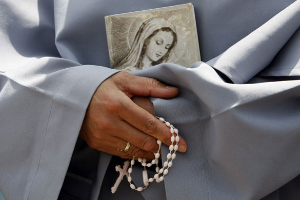 Pope Benedict: A nun holds a rosary and a picture of a saint