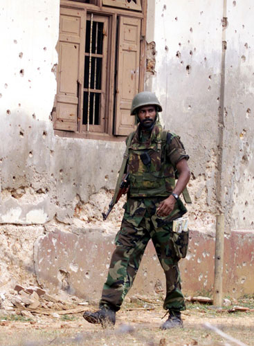 Tamil Tigers surrender: sri lankan soldier patrols the jaffna suburb in 2000