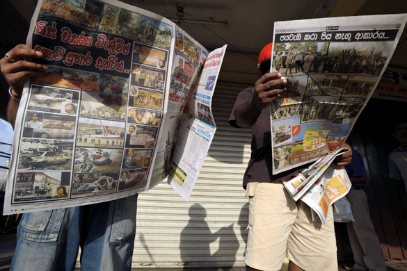 Tamil Tigers surrender: Sri Lankan people read newspapers which report the victory over the LTTE  