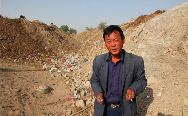 Minqin China: Huang at the bottom of a dried-up river that once ran past his his old home