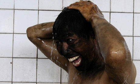 A coal miner takes a shower after his shift in China