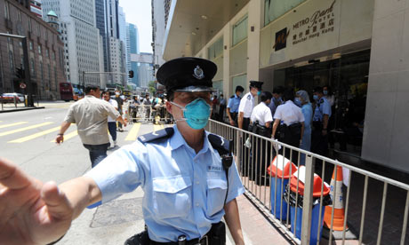 A policeman guards Hong Kong's Metropark hotel, which is under swine flu quarantine