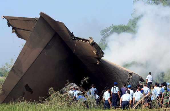 Indonesian plane crash: Soldiers and rescue workers around the still smouldering plane