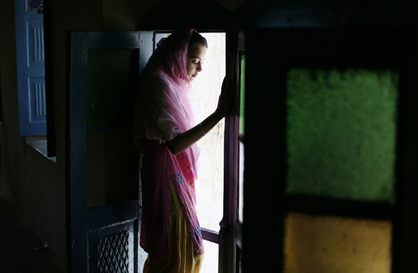 20 May 2009: Hasanabdal, Pakistan: A girl looks out of a room at a Sikh temple