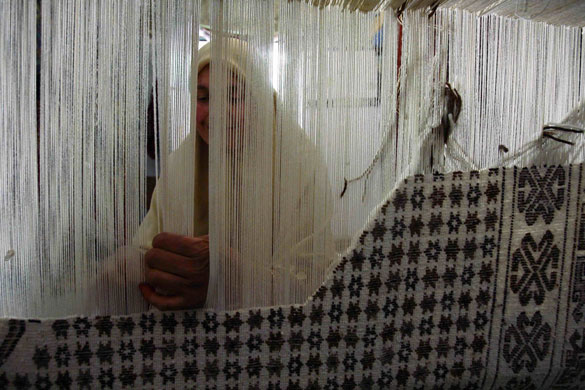 20 May 2009: Babar, Algeria: A woman weaves carpet at her house