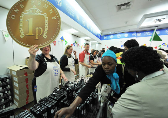 Marks and Spencer: A woman holds up a promotional Marks and Spencer penny