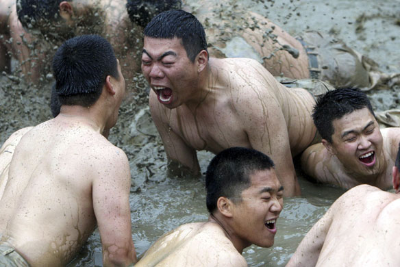 21 May 2009: Anyang, South Korea: Soldiers in a mud pool during a military exercise