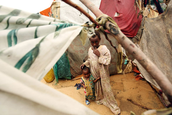 22 May 2009: Mogadishu, Somalia: A boy and a girl stand next to a tent at a camp