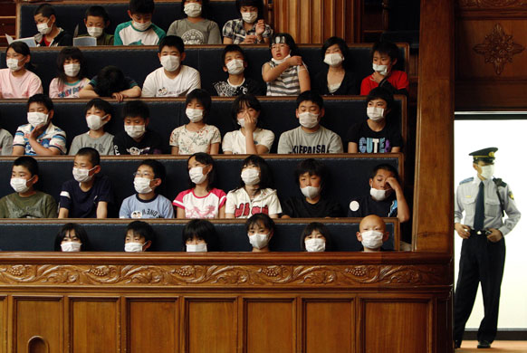 22 May 2009: Tokyo, Japan: Elementary school students and a guard wear masks