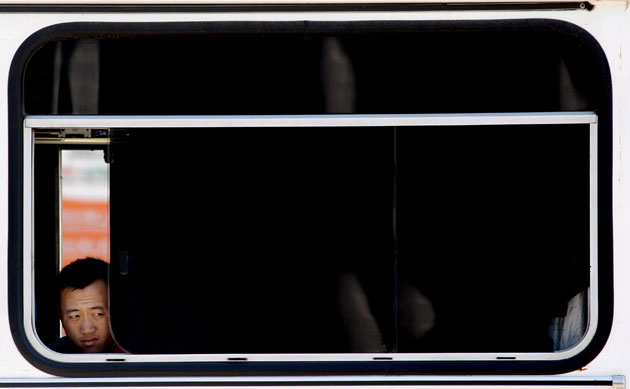 22 May 2009: Beijing, China: A policemen looks out of a surveillance vehicle