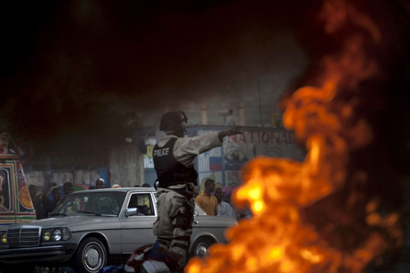 24 hours in pictures: Port-au-Prince, Haiti: A riot police officer gestures during a protest