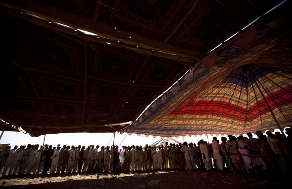 24 hours in pictures: Peshawar, Pakistan: Pakistani displaced men wait in a queue 