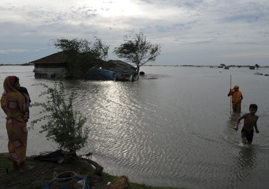 Cyclone Aila: Villagers walk through their flooded village in West Bengal