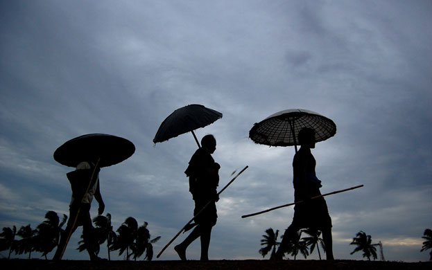 Cyclone Aila: Bhubaneswar, India: Villagers walk against a backdrop of cyclone clouds 