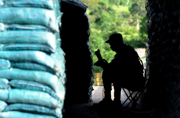 26 May 2009: San Jose del Guaviare, Colombia: A soldier cleans his rifle