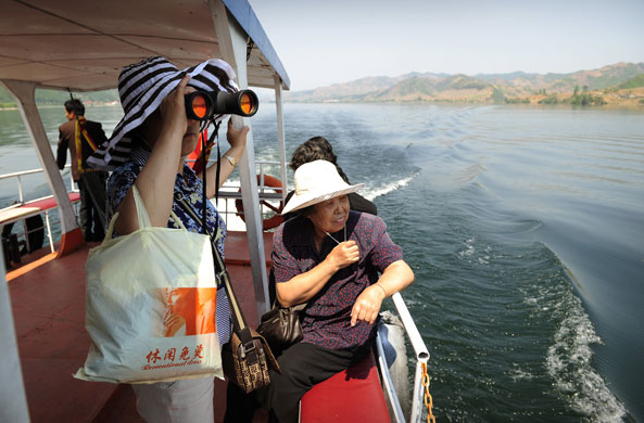 North Korea : Chinese tourists view North Korea from a boat on the Yalu River 
