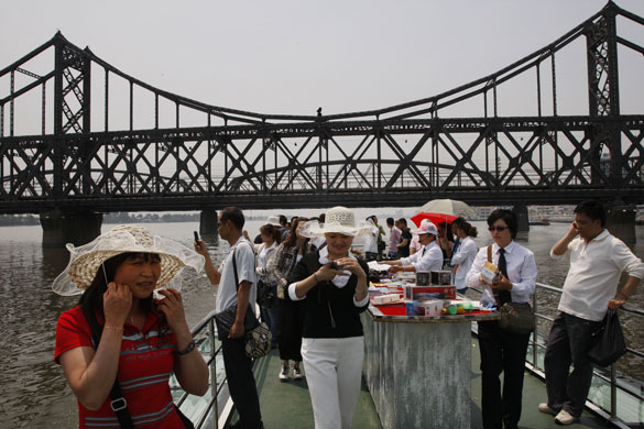 North Korea : Chinese tourists on board a tour boat cruising along the Yalu River