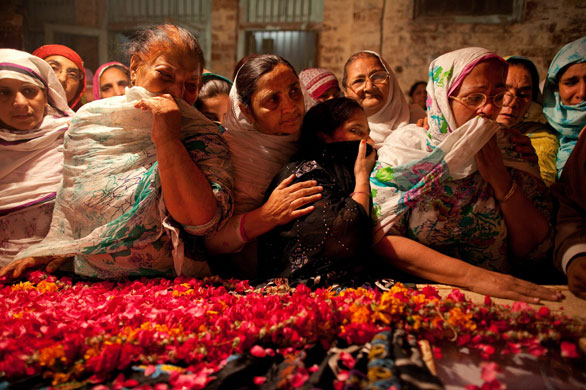 28 May 2009: Lahore, Pakistan: Women mourn over the body of Inspector Abdul Rauf Sultan