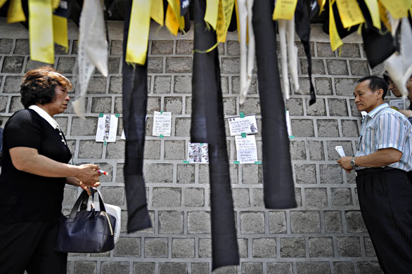 28 May 2009: Seoul: People walk past ribbons displayed in honour of Roh Moo-Hyun