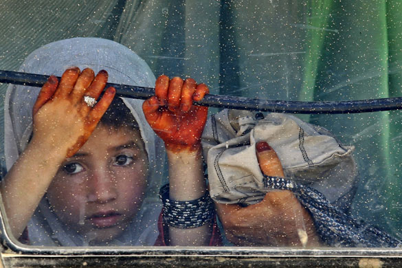 28 May 2009: Bazaar e Panjwai, Afghanistan: A girl looks at Canadian soldiers on patrol