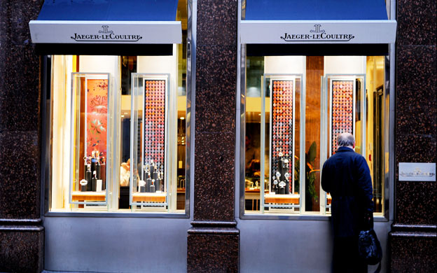 Week in business: A man looks at expensive watches in the Jaeger-LeCoultre shop window