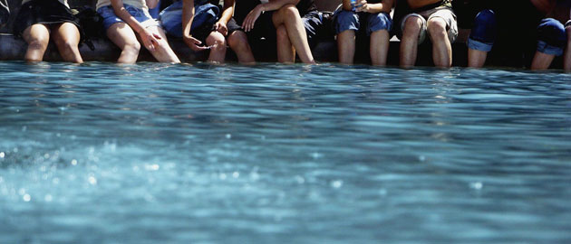 Trafalgar Square fountain: Passers-by dip their feet in a fountain during a hot summer